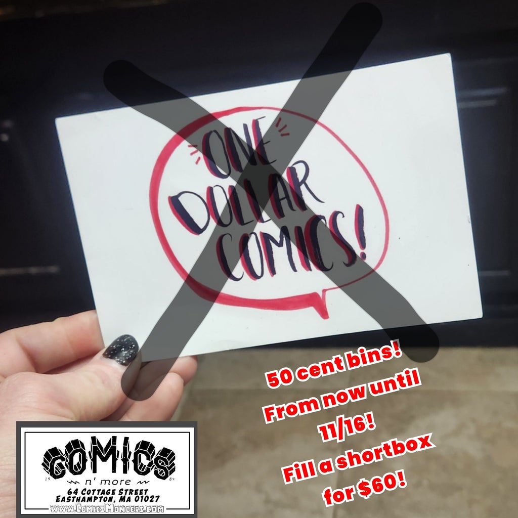 My hand is holding a print that reads One Dollar Comics in a red a black font in center of a red "voice bubble" as used to attribute dialog in comics. There's an x across it in grey. Below is the comics nmore logo. Next to it reads (in red with white border font) "50 cent bins! From now until" and then (in yellow with black outline) on a new line it says "November 23rd!" Then below that in red and white outlined letters it says "fill a short box for $60!"